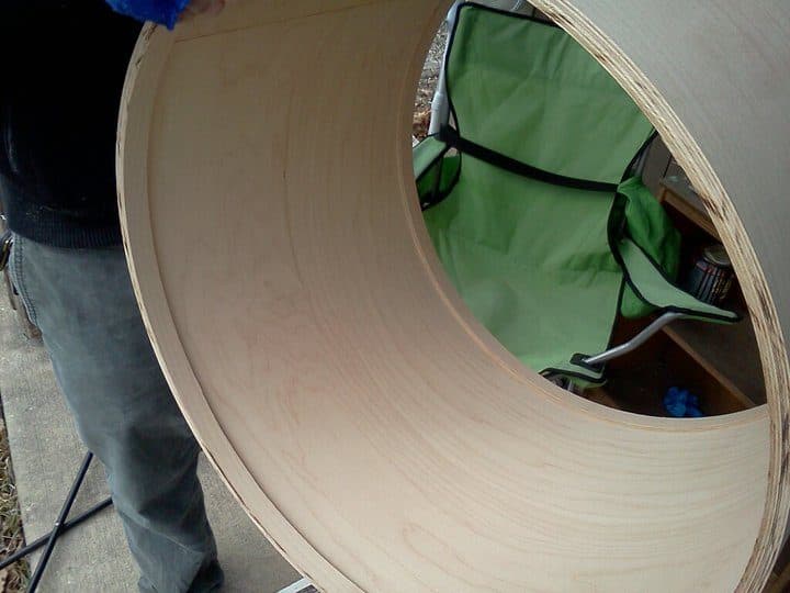 A raw maple bass drum shell with reinforcement rings installed